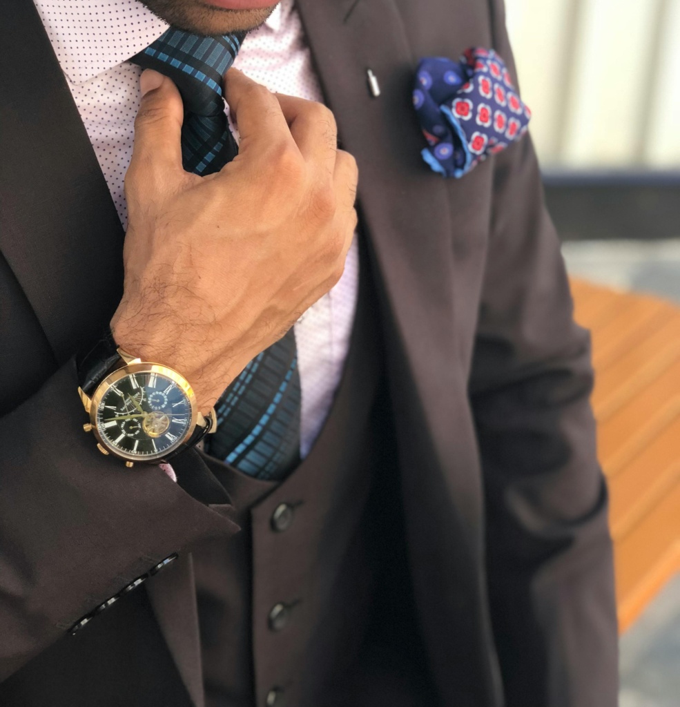 pexels-photo-1342609-1342609 Elegant close-up of a man in a designer suit adjusting his tie, showcasing luxury fashion.
