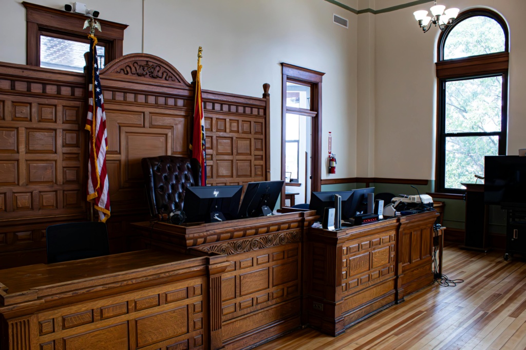 pexels-photo-17630959-17630959 Interior view of an American courthouse in Kirksville, Missouri, featuring a judge's desk and flags.